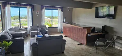 a living room with couches and a flat screen tv at Hotel Almore in Monteverde Costa Rica