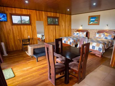 a bedroom with two beds and a table and chairs at Hotel Almore in Monteverde Costa Rica
