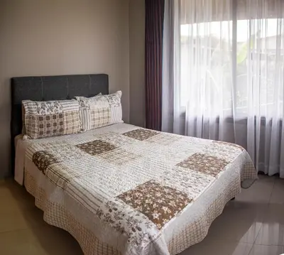 a bedroom with a bed with a blanket and a window at Hotel Almore in Monteverde Costa Rica