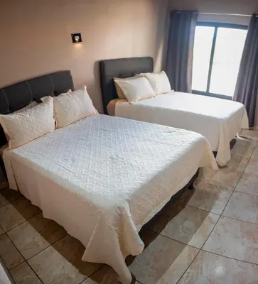 two beds sitting next to each other in a room at Hotel Almore in Monteverde Costa Rica