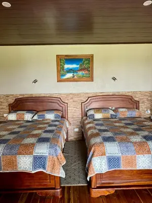 a bedroom with two beds and a painting on the wall at Hotel Almore in Monteverde Costa Rica