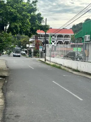 a bus is driving down a street with buildings at Apartamento BYES in Quepos