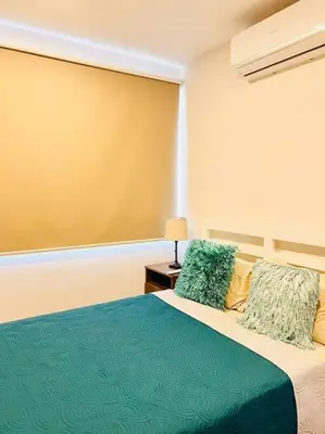 a bedroom with a bed with a blue blanket and pillows at Casa Bellota in Marbella