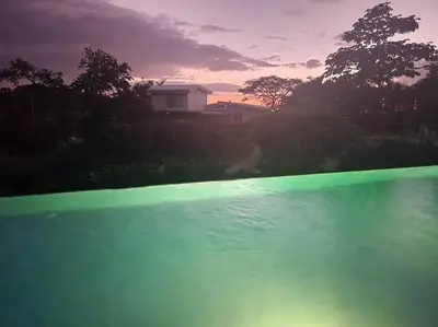 a green pool of water with a house in the background at Casa Bellota in Marbella