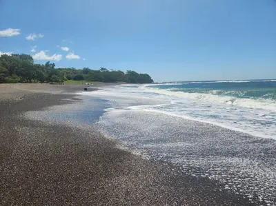 a beach with the ocean and the waves at Casa Bellota in Marbella