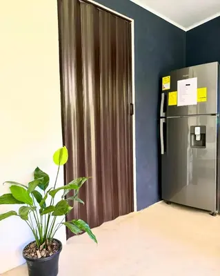a refrigerator in a room with a plant next to it at Deer House Cabuya in Cabuya