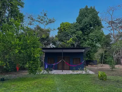 a small blue house with a red and blue banner at Deer House Cabuya in Cabuya