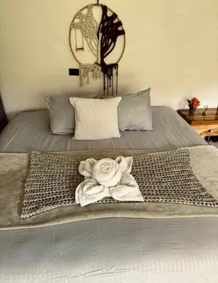 a bed with a white towel on top of it at Deer House Cabuya in Cabuya
