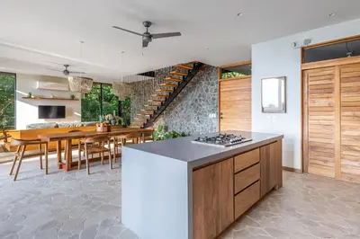 a kitchen and dining room with a staircase in the background at Brand-new luxury Villa Element in Carmen