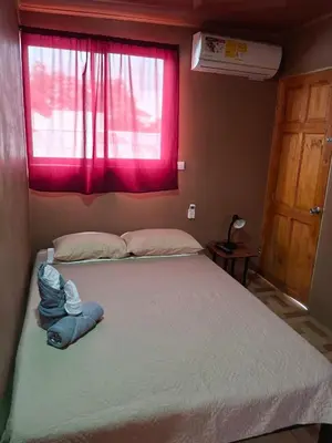 a bedroom with a large bed with a pink window at Pocho's Place Rio Celeste in San Antonio