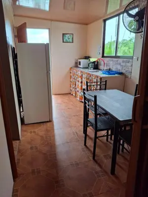 a kitchen with a table and a refrigerator at Pocho's Place Rio Celeste in San Antonio