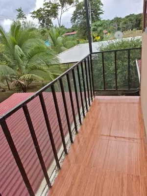 a balcony with a wooden floor and a railing at Pocho's Place Rio Celeste in San Antonio