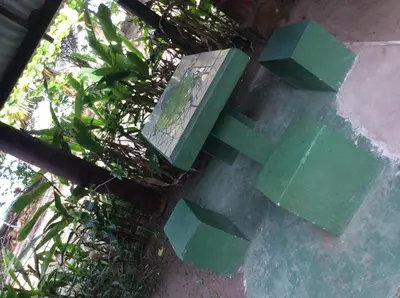 a green bench sitting on the ground in the grass at Cabinas Balcon del Mar Tortuguero in Tortuguero
