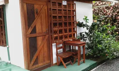 a wooden door and a wooden stool next to a door at Cabinas Balcon del Mar Tortuguero in Tortuguero