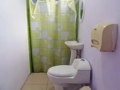 a small bathroom with a toilet and a sink at Cabinas El Muellecito in Tortuguero