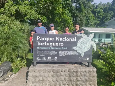 a group of people standing on top of a sign at Cabinas El Muellecito in Tortuguero