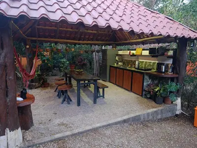 a kitchen with a table and chairs under a pavilion at Aura Bungalow in Tamarindo