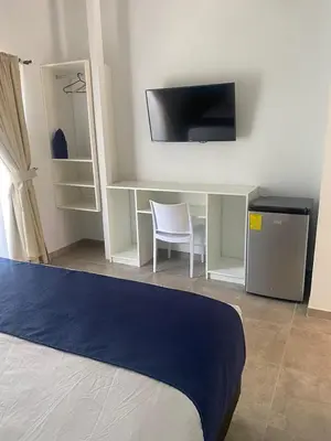 a bedroom with a desk with a tv and a chair at Club Marino Ballena in Uvita