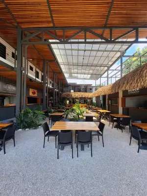 a cafeteria with tables and chairs in a building at Club Marino Ballena in Uvita