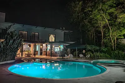 a swimming pool in front of a house at night at Club Marino Ballena in Uvita