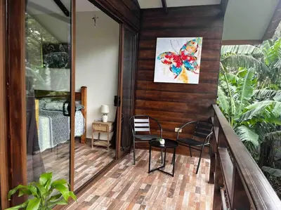 a balcony with two chairs and a table and a painting at Casa Colibrí in Tilarán