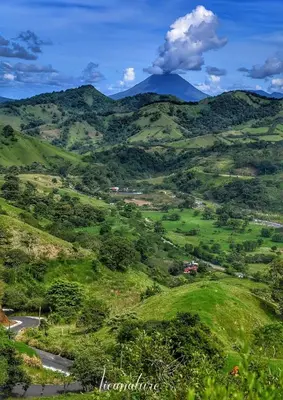 a green valley with a mountain in the background at Casa Colibrí in Tilarán