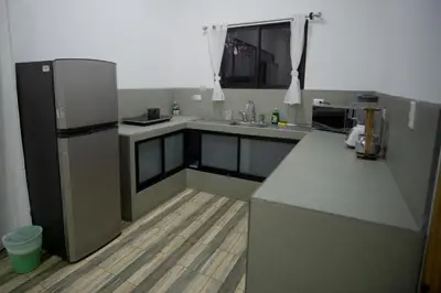 a kitchen with a refrigerator and a counter top at Hills House Pinilla Guanacaste in San José Pinilla
