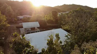 an overhead view of a house with the sun in the background at Hills House Pinilla Guanacaste in San José Pinilla