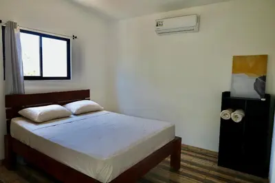 a bedroom with a bed and a window at Hills House Pinilla Guanacaste in San José Pinilla