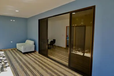 a living room with a white couch and a chair at Hills House Pinilla Guanacaste in San José Pinilla