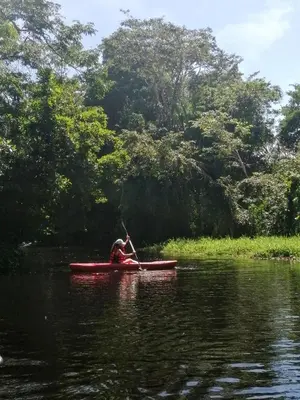 a person in a red kayak on a river at Hospedaje Meryscar in Tortuguero