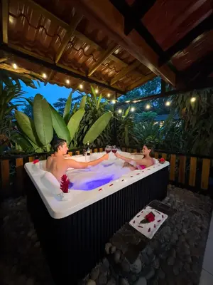 two people in a bath tub in a garden at Hotel Rancho Cerro Azul in Fortuna