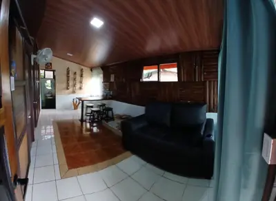 a living room with a black couch and a table at Cabaña que Tuanis in Fortuna