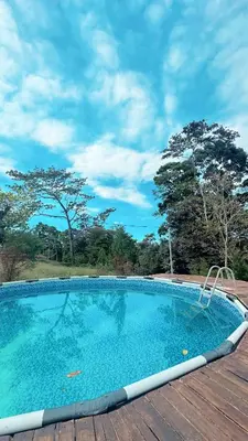 a large swimming pool on top of a wooden deck at Cabaña Magui. in Aguas Zarcas