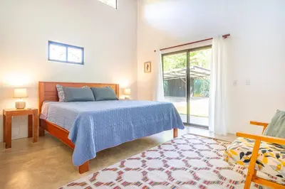 a bedroom with a bed and a large window at Luxury 2 bedroom, walking distance to beach in Uvita