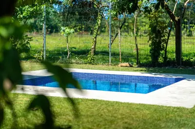 a swimming pool in a yard with a fence at Luxury 2 bedroom, walking distance to beach in Uvita