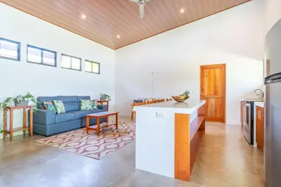 a kitchen and living room with a blue couch at Luxury 2 bedroom, walking distance to beach in Uvita