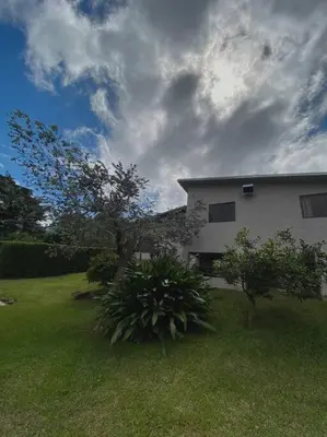 a white house with trees and a grass yard at Peace Garden Apartment in Monteverde Costa Rica