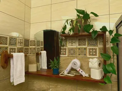 a bathroom with a hair dryer on a shelf with towels at Peace Garden Apartment in Monteverde Costa Rica
