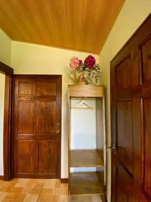 a hallway with a door and a vase of flowers at Peace Garden Apartment in Monteverde Costa Rica
