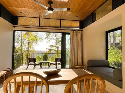 a dining room and living room with a table and chairs at Purapura Santa Teresa in Santa Teresa Beach