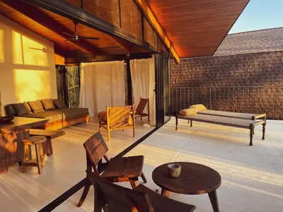 a living room with a couch and tables and chairs at Purapura Santa Teresa in Santa Teresa Beach