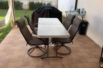 a white table and four black chairs in a yard at Casa de playa, Bejuco Costa Rica in Bejuco