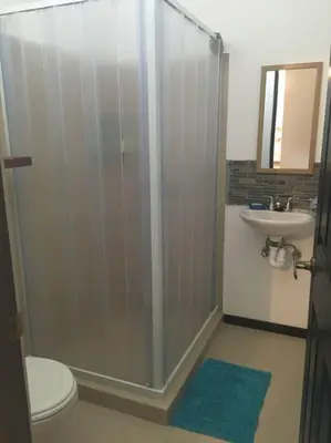 a bathroom with a shower and a toilet and a sink at Casa de playa, Bejuco Costa Rica in Bejuco
