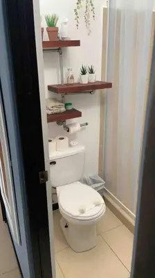 a bathroom with a toilet and shelves on the wall at Casa de playa, Bejuco Costa Rica in Bejuco