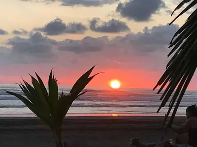 a person sitting on the beach watching the sunset at Casa de playa, Bejuco Costa Rica in Bejuco