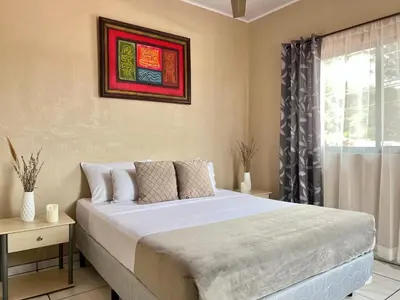 a bedroom with a large bed and a window at Casa Tatich AC near Guanacaste Airport in Liberia