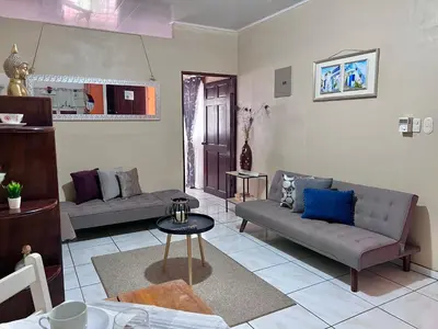a living room with two couches and a table at Casa Tatich AC near Guanacaste Airport in Liberia