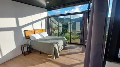 a bedroom with a bed and a large window at Mon Bellis in El Copey