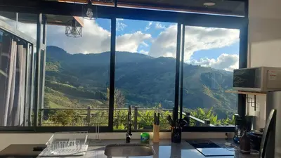 a kitchen with a large window with a mountain view at Mon Bellis in El Copey